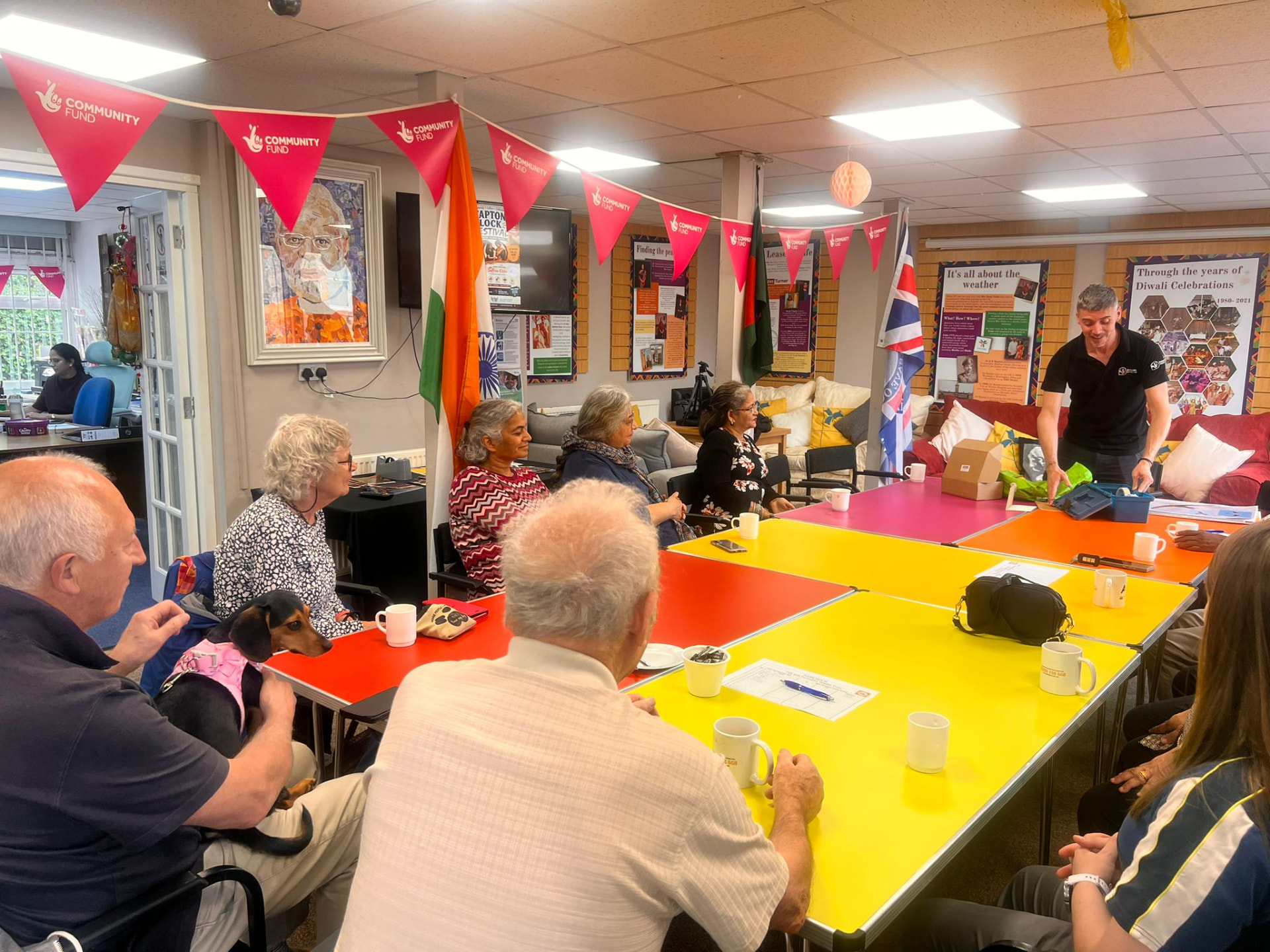 A facilitator unpacking nature session materials beside colourful tables at the Asian Association Chesterfield