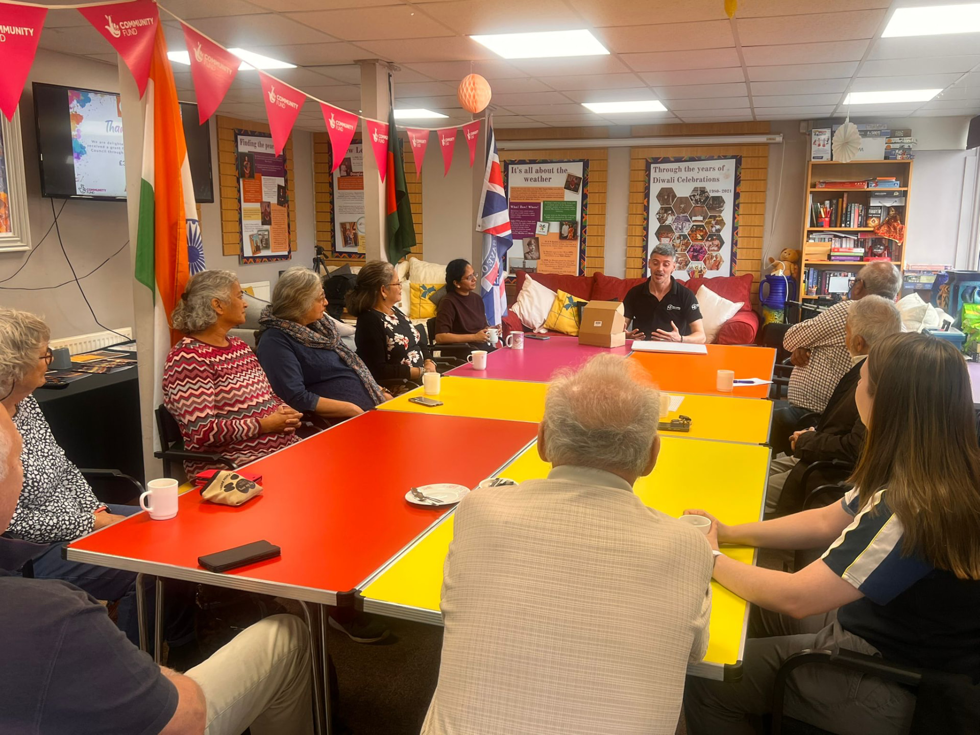 A facilitator speaking to seated members of the Asian Association Chesterfield during an indoor nature connectedness session